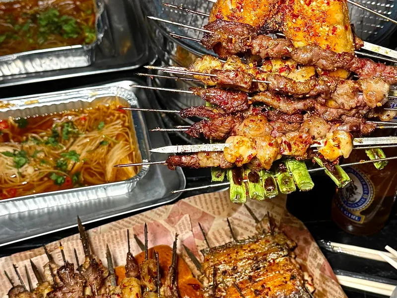 Grilled Chinese BBQ skewers — lamb, chicken wings and fish with cumin and chili, a street food classic